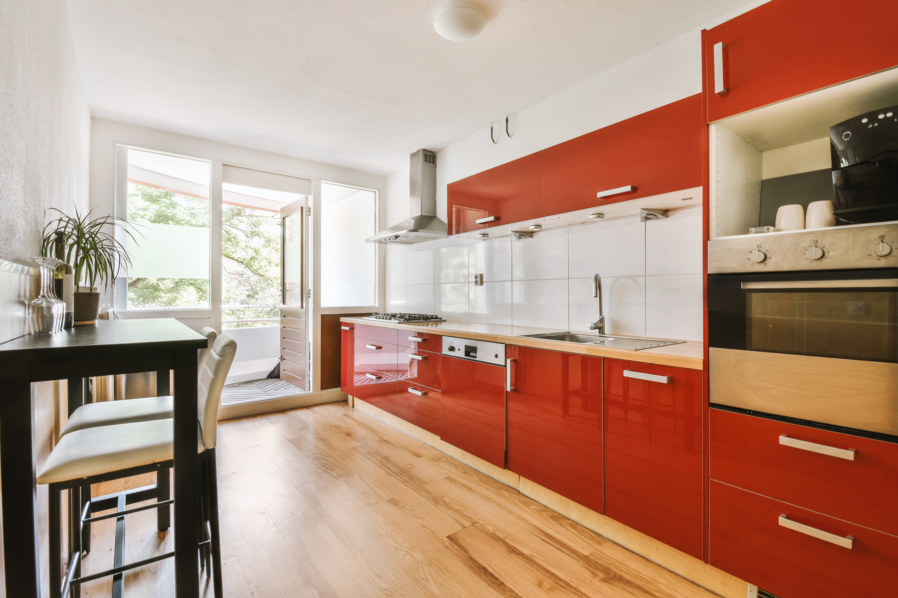 Home interior design of modern loft apartment with open kitchen in minimalist style and spacious dining zone with table and chairs